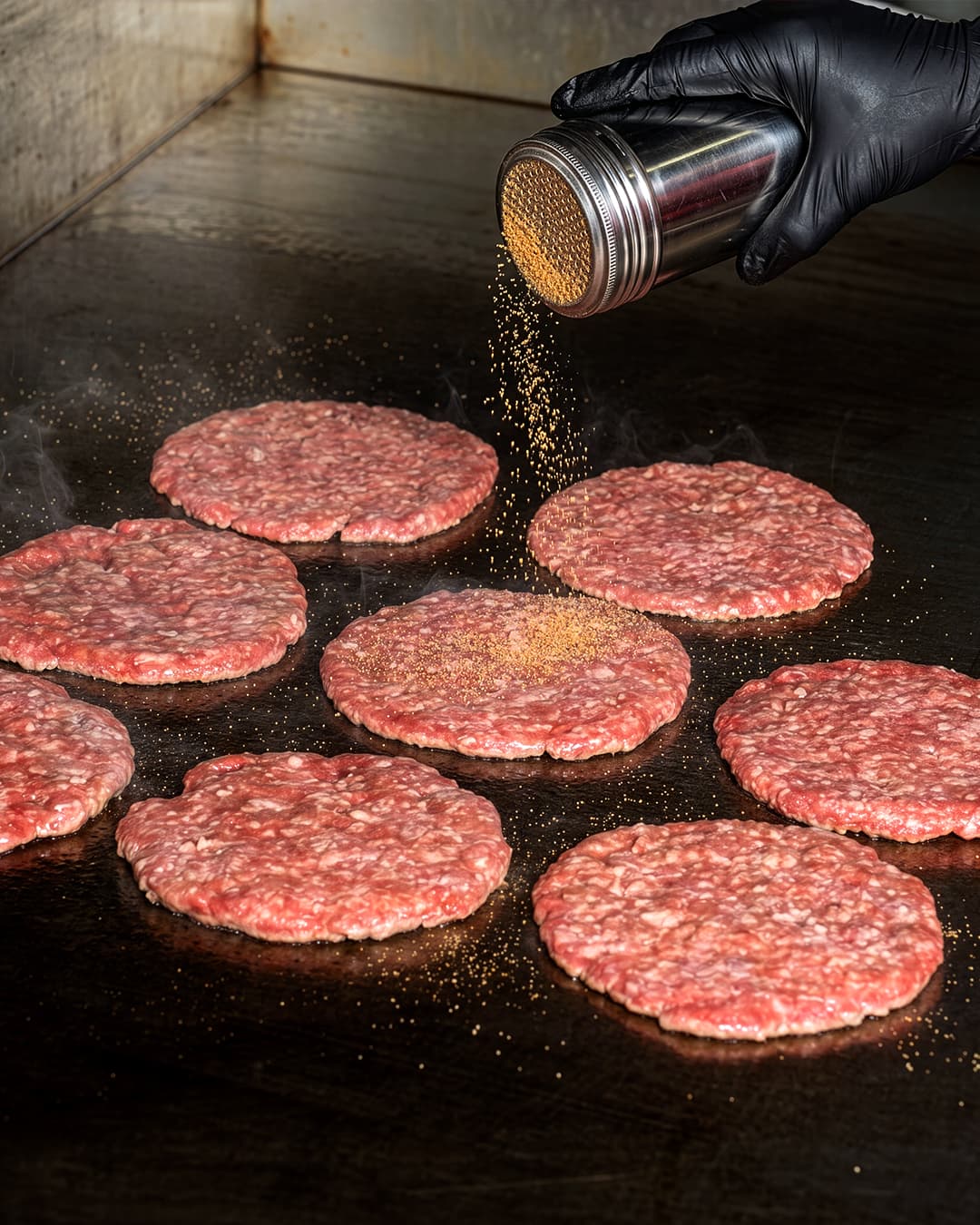 A fresh patty searing on the grill